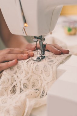Dikiş makinesi üzerinde çalışan terzi.