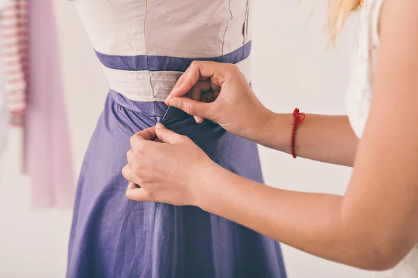 Woman pinning a dress — Stock Photo, Image