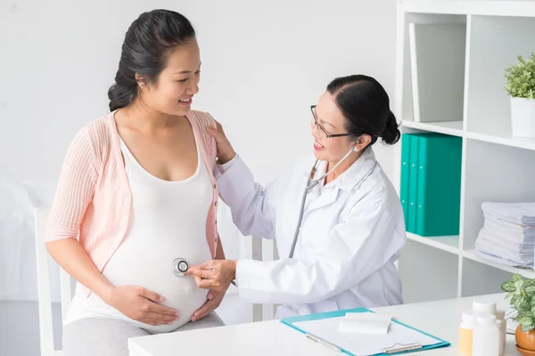 Docteur écoute le ventre de la femme enceinte — Photo