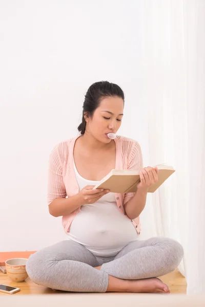 怀孕的女人拿着一本书 — 图库照片