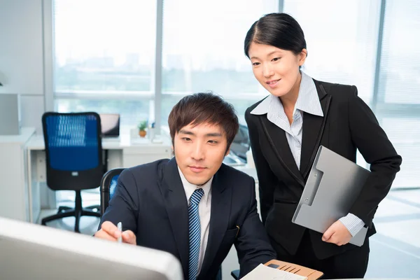 Empresarios coreanos leyendo alguna información — Foto de Stock