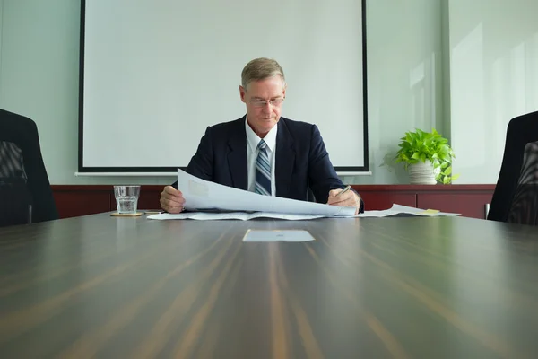 Businessman examining blueprint — Stock Photo, Image