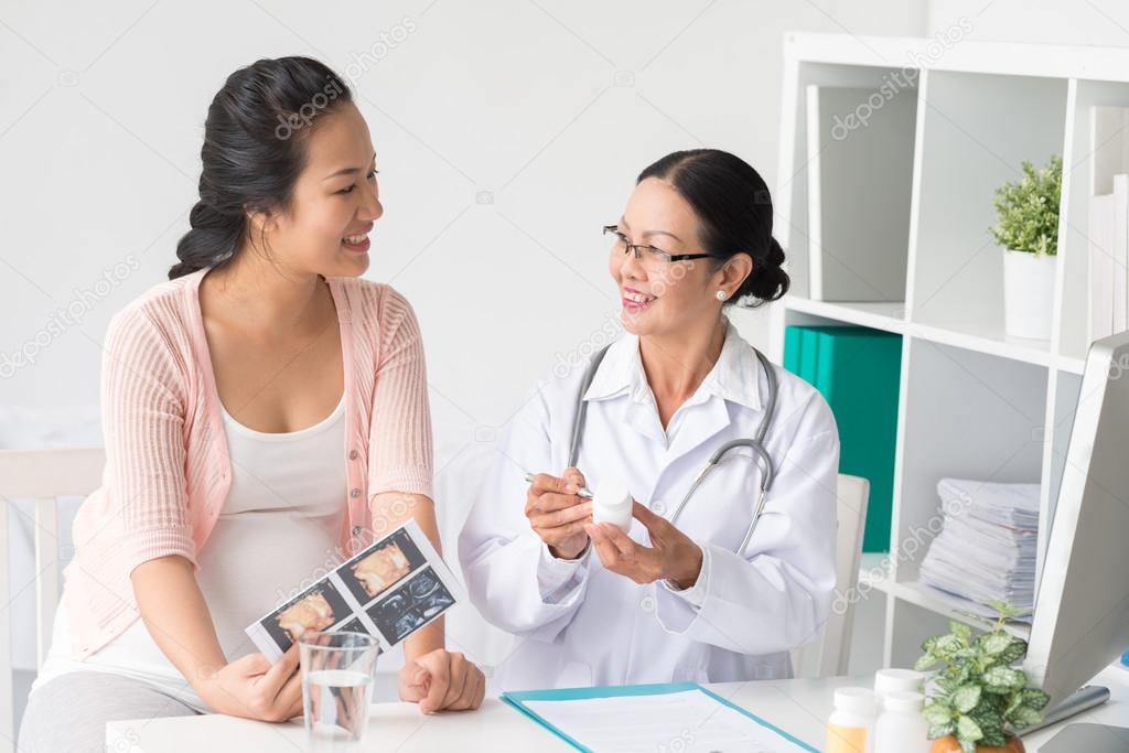 Doctor prescribing vitamins to pregnant patient
