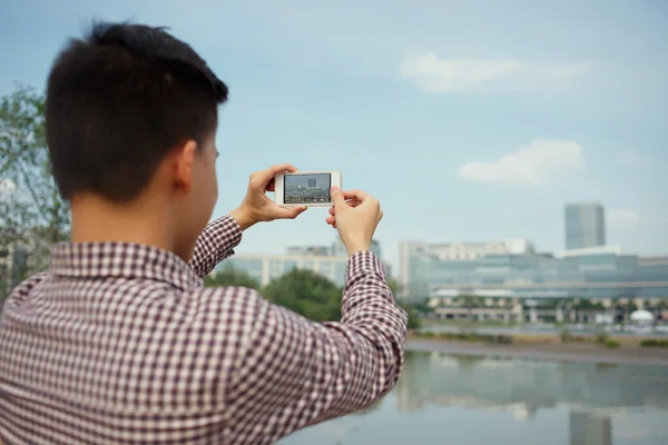 Hombre tomando fotos del paisaje urbano — Foto de Stock