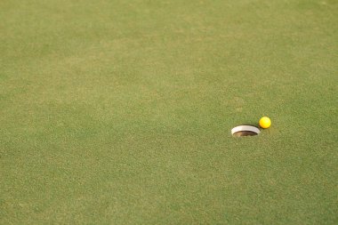 Golf ball on lip of cup