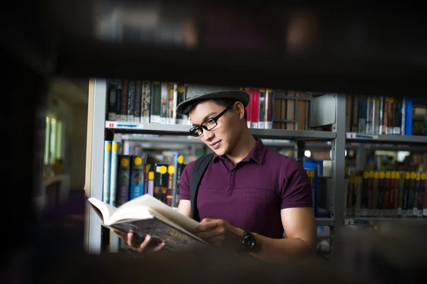 Uczeń czytania książki w bibliotece — Zdjęcie stockowe