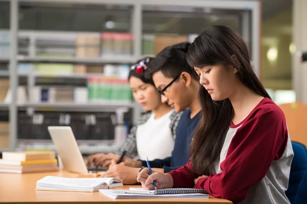 Adolescentes estudiando en una biblioteca —  Fotos de Stock