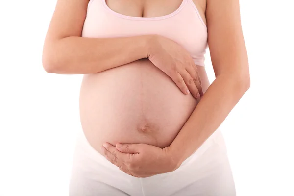 Gravid kvinna med händerna över magen — Stockfoto