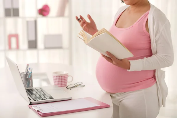 Gravid kvinna läser en bok — Stockfoto