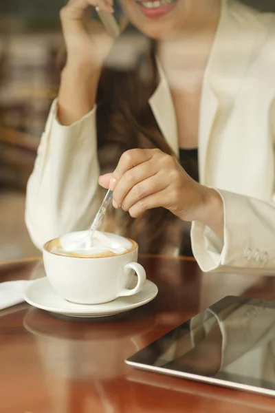 Kvinna med kopp kaffe och prata i telefon — Stockfoto