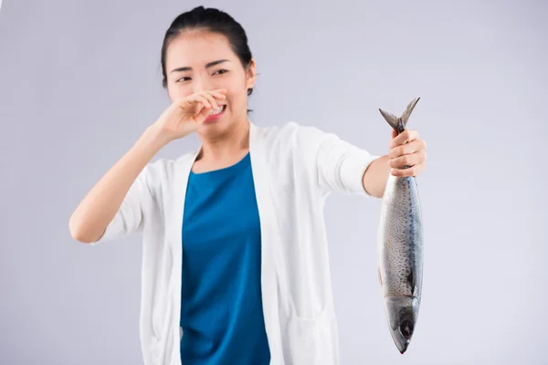 Mädchen hält einen stinkenden Fisch in der Hand — Stockfoto