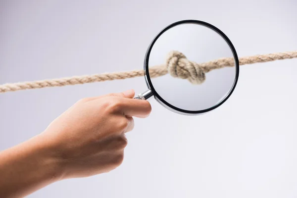 Hand with magnifier over marine knot — Stock Photo, Image