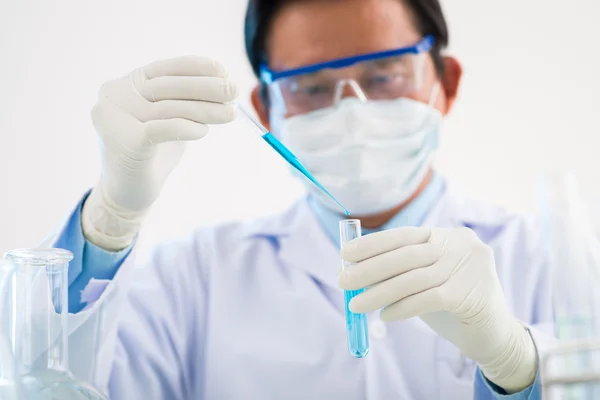 Scientist looking at tube — Stock Photo, Image