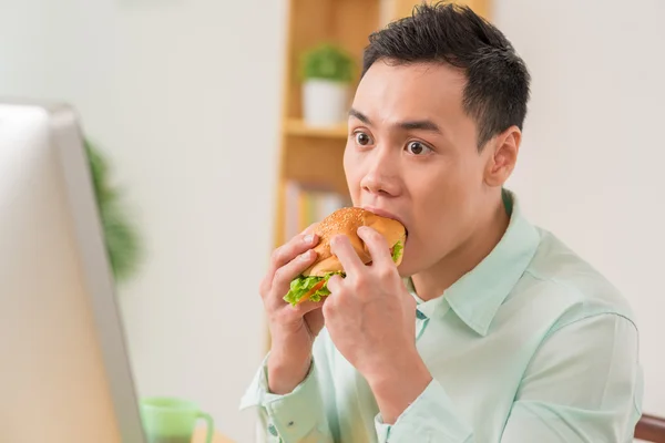 Člověk jíst hamburger — Stock fotografie