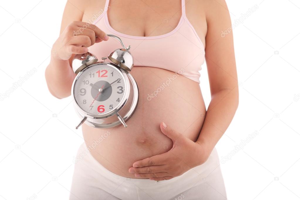 Pregnant woman with alarm clock