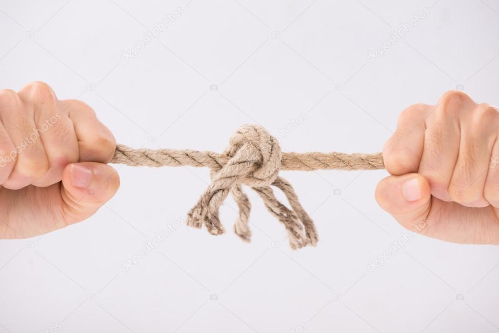 Hands tearing rope