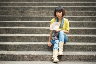 Merdivenlerde oturan kadın.