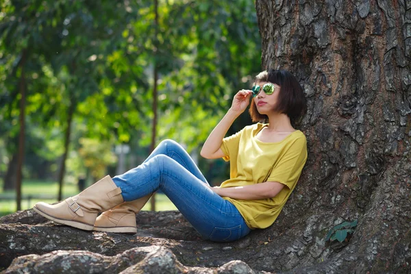 Dívka sedí pod stromem — Stock fotografie