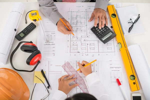 Ingenieurs die werkzaam zijn op blauwdruk — Stockfoto