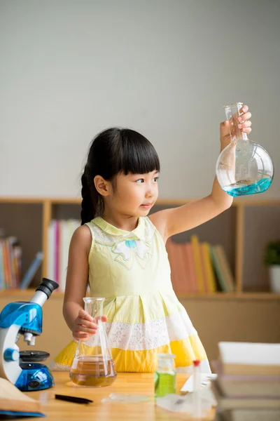 Girl looking at flask — Stock Photo, Image