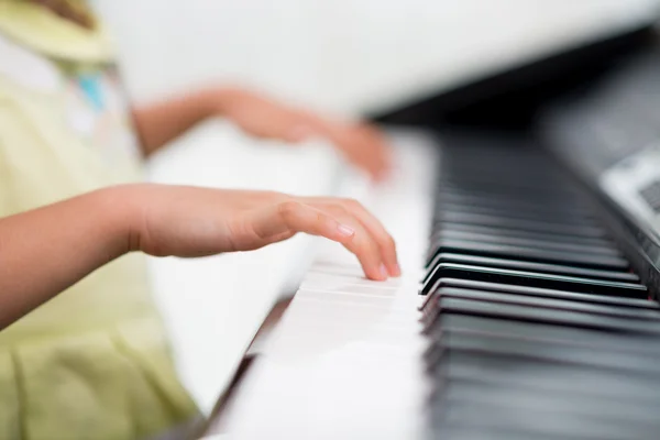 Handen van kind speelde piano — Stockfoto