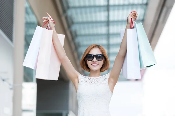 Vrouw verhogen handen met shopping tassen — Stockfoto