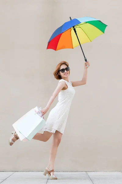 ผู้หญิงที่มีร่มและถุงช้อปปิ้ง — ภาพถ่ายสต็อก