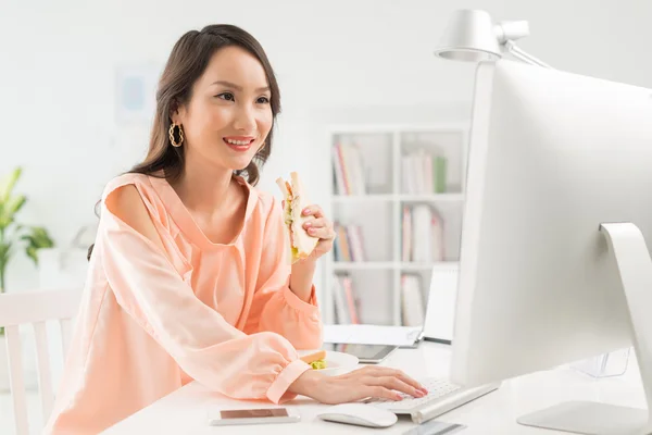 アジアの女性は、サンドイッチを食べて — ストック写真