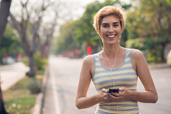 Corredor femenino alegre en auriculares — Foto de Stock