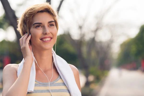 Sportliche Frau hört Musik — Stockfoto