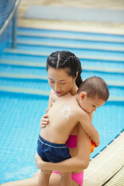 Kobieta stosowania ochrony przeciwsłonecznej na jej syna — Zdjęcie stockowe