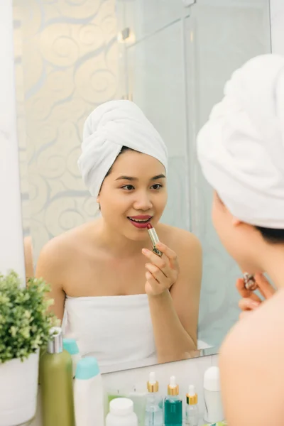 Mujer aplicando lápiz labial rojo —  Fotos de Stock