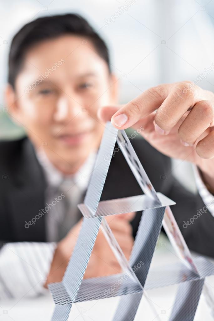 Businessman building house of cards