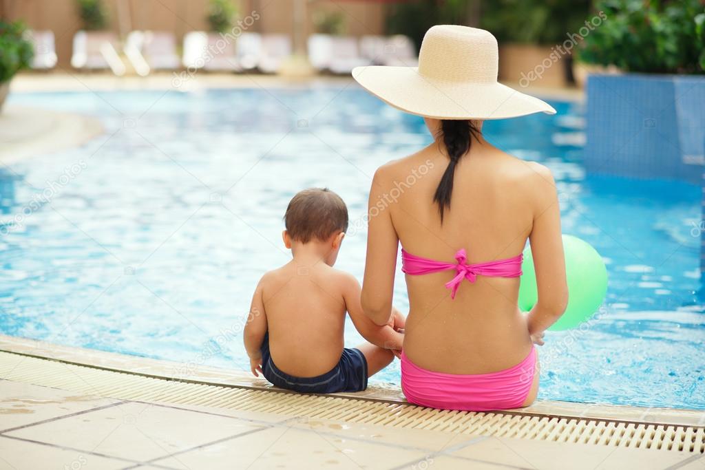 Mother and son sitting on the swimming pool