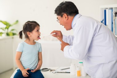 Çocuk doktoru ağız termometresi kullanarak