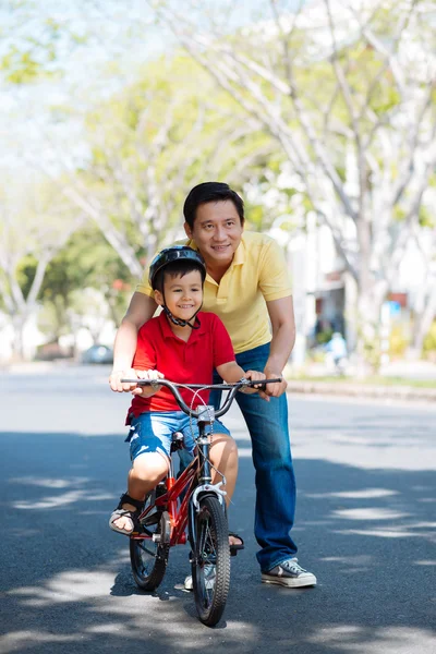 Hombre enseñando a niño a montar — Foto de Stock