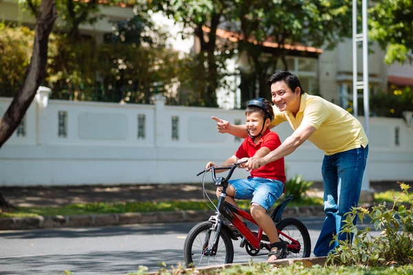 男子教学儿子骑自行车 — 图库照片