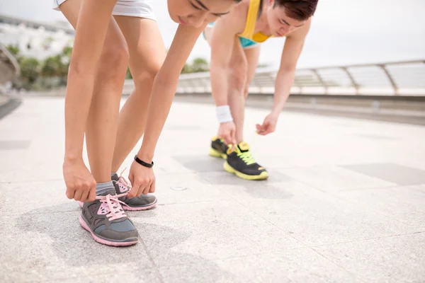 Joggers tying shoelaces — Stock Photo, Image