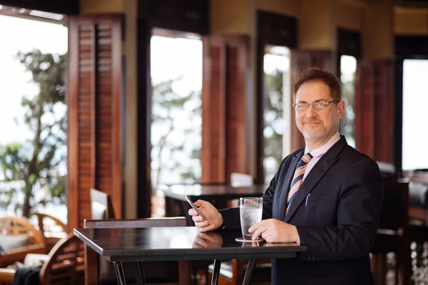 Uomo d'affari con smartphone nel caffè — Foto Stock