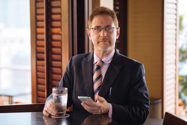 Homme d'affaires avec smartphone dans un café — Photo