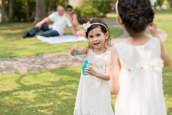 Menina gostando de soprar bolhas de sabão — Fotografia de Stock