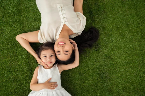 Mãe e filha deitada na grama — Fotografia de Stock