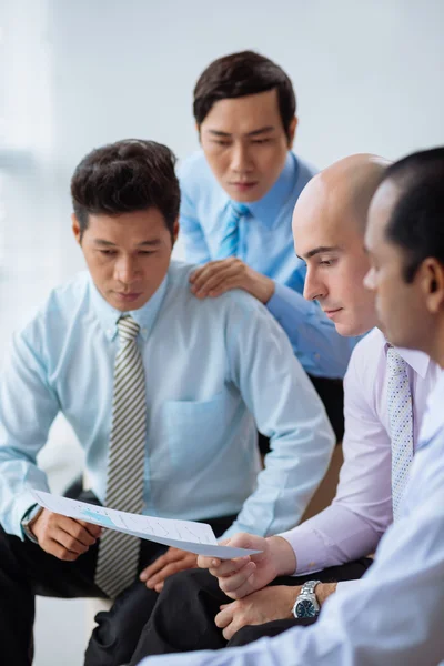 Businessmen reading financial report — Stock Photo, Image