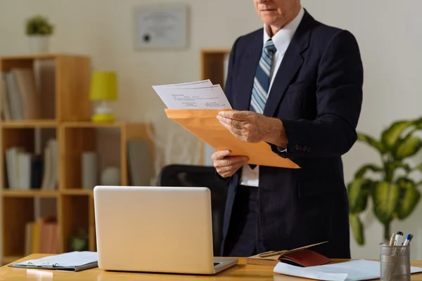 Mature businessman reading correspondence — Stock Photo, Image