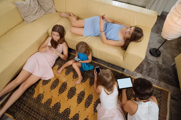 Moeder en dochters gadgets gebruiken — Stockfoto