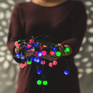 Noel ışıkları tutan kadın