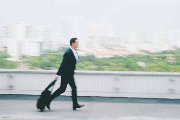Бізнесмен з валізою біжить — стокове фото