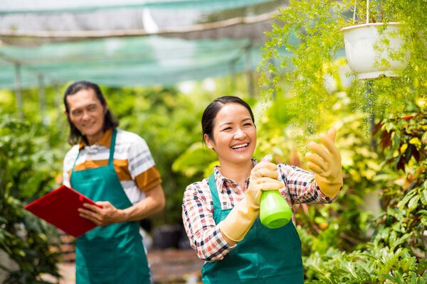 woman spraying water on plants