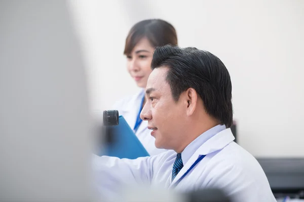 Optometrista usando equipamento profissional — Fotografia de Stock