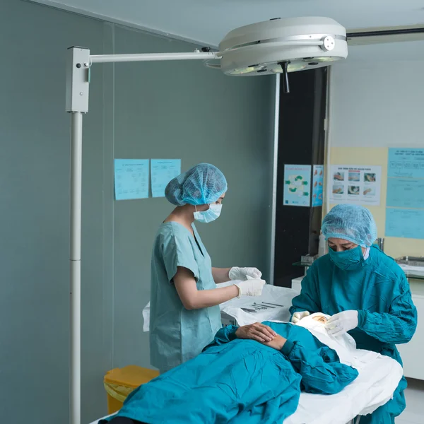 Médico e enfermeiro realizando operação — Fotografia de Stock